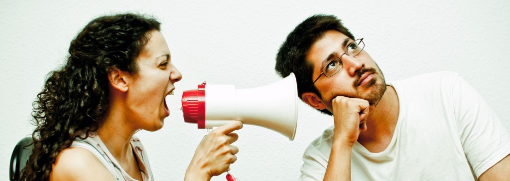 Woman using a megaphone to yell at a man